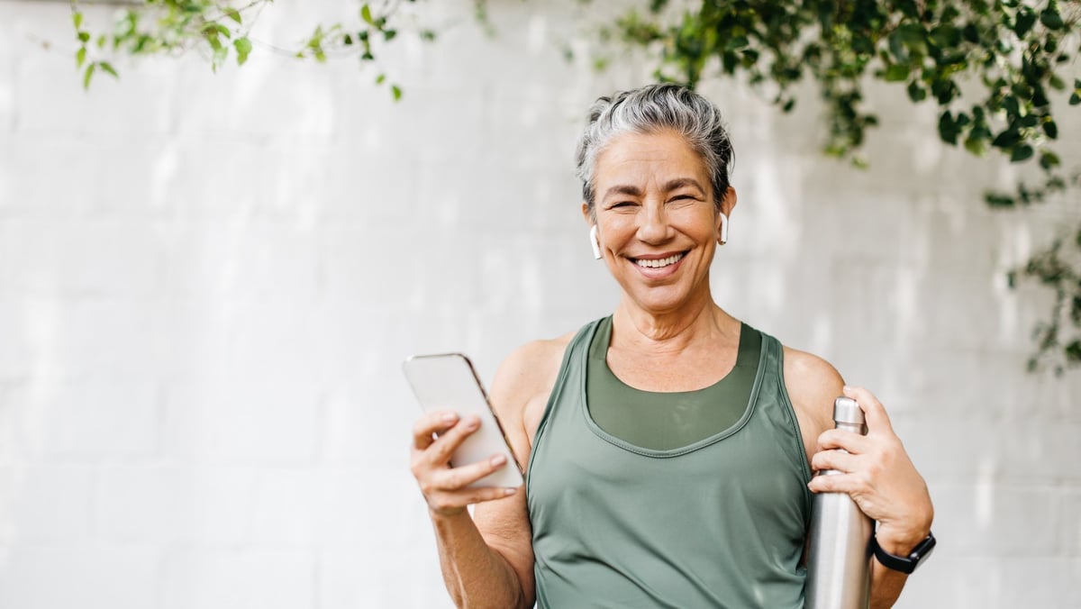 Active senior woman with a happy smile using her smartphone outdoors